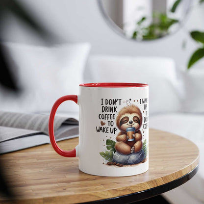Cute sloth coffee mug with cheerful design and red handle on a wooden table.