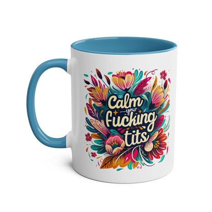 Colorful "Calm Your Tits" coffee mug with floral design, blue handle and interior.