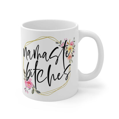 White ceramic mug with "namaste bitches" text and floral design, glossy finish, 11oz, microwave and dishwasher safe