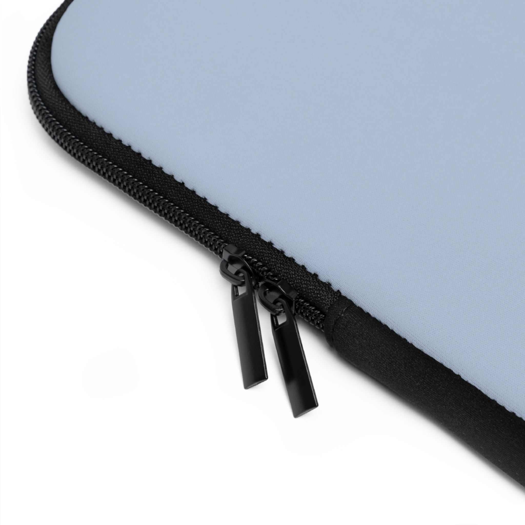Close-up of misty blue laptop sleeve with black dual zipper and neoprene material