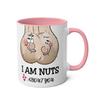 White ceramic "I Am Nuts About You" mug with pink handle and rim featuring cheeky cartoon nuts design