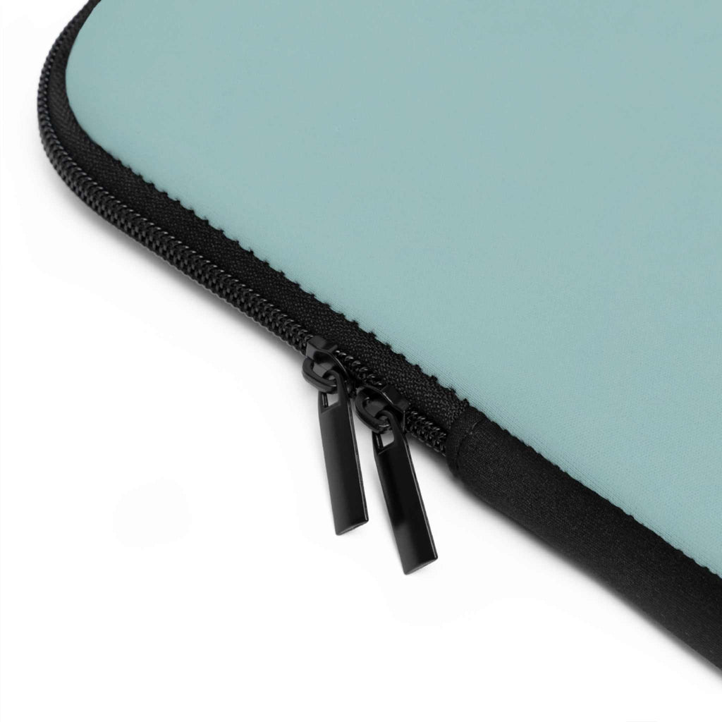 Close-up of teal green laptop sleeve corner with black dual zipper and smooth neoprene material