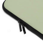 Close-up of sage green neoprene laptop sleeve with black dual zipper and soft foam lining