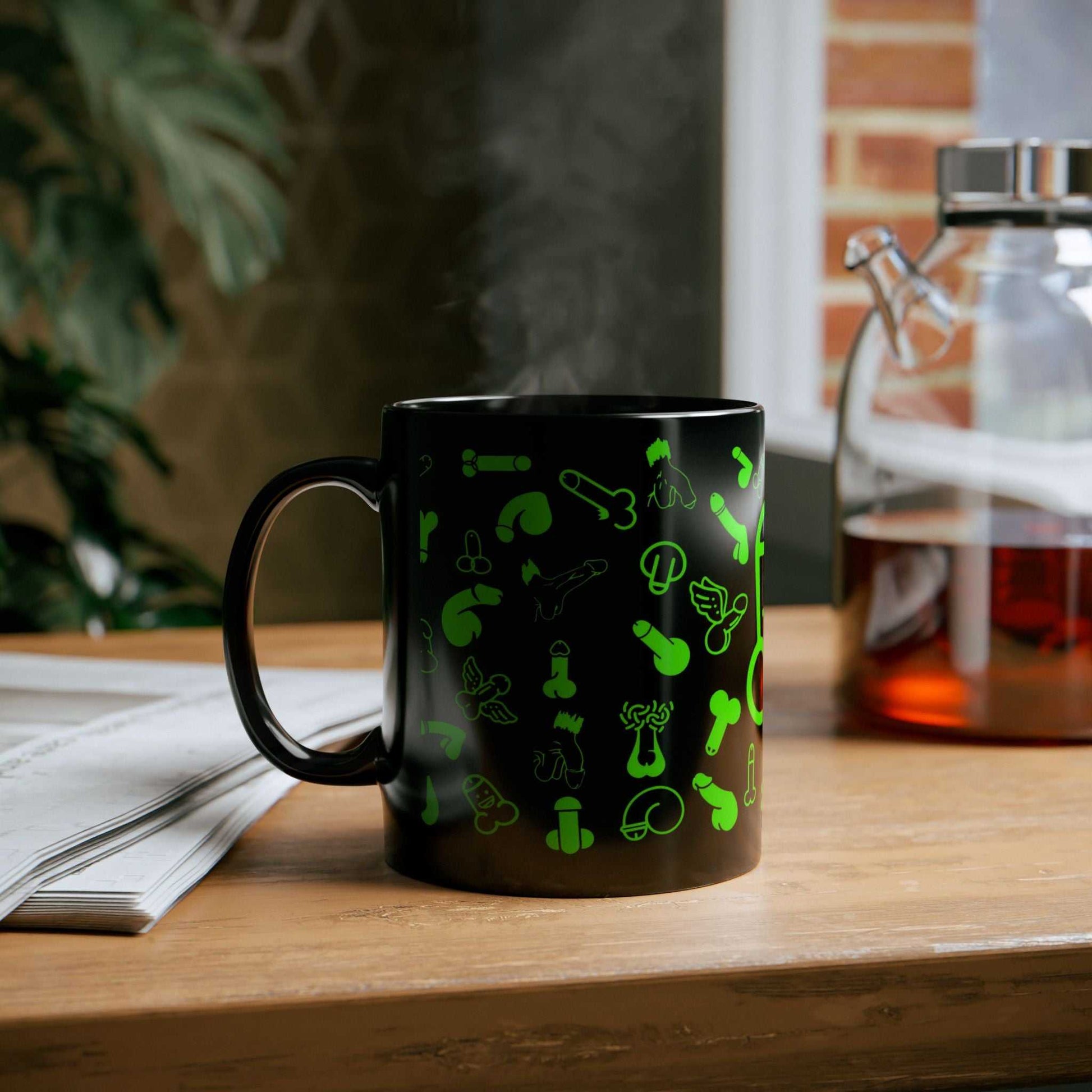 Black ceramic mug with playful green willie design, glossy finish, available in 11oz and 15oz sizes, ideal for adding fun to your coffee routine.