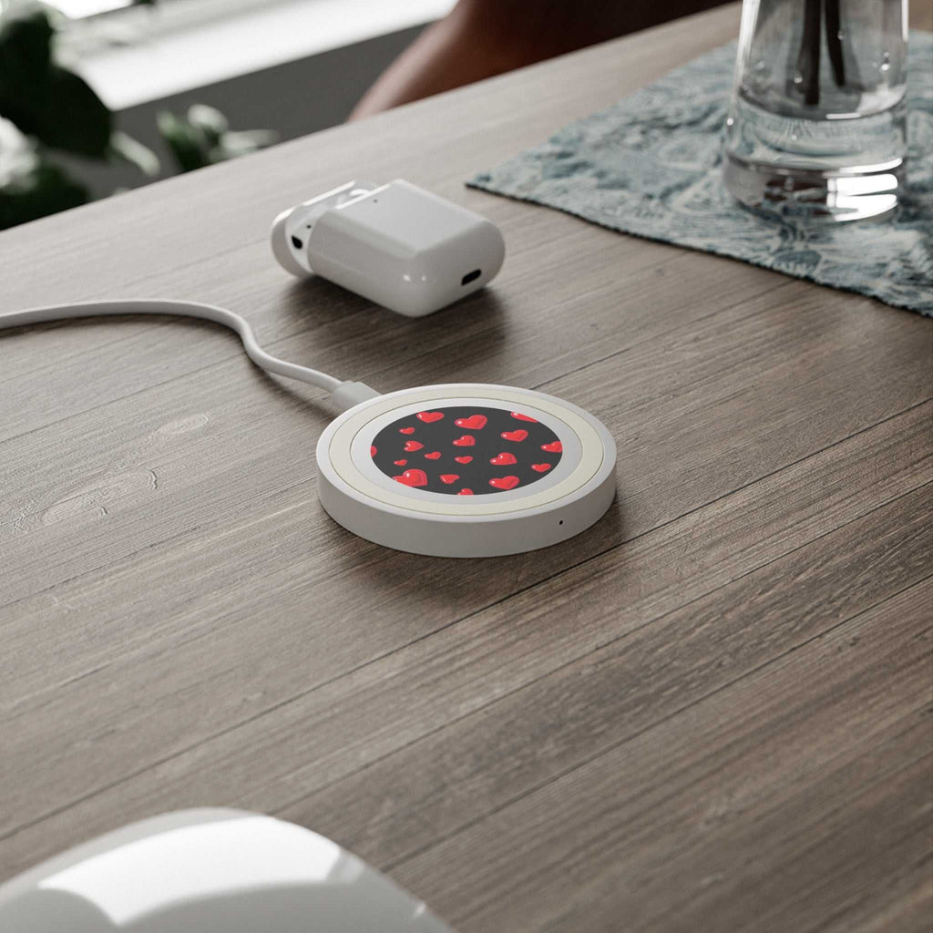 Compact black hearts design wireless charging pad with 5W power on wooden desk with charger