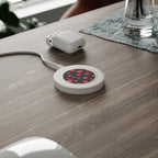Compact black hearts design wireless charging pad with 5W power on wooden desk with charger