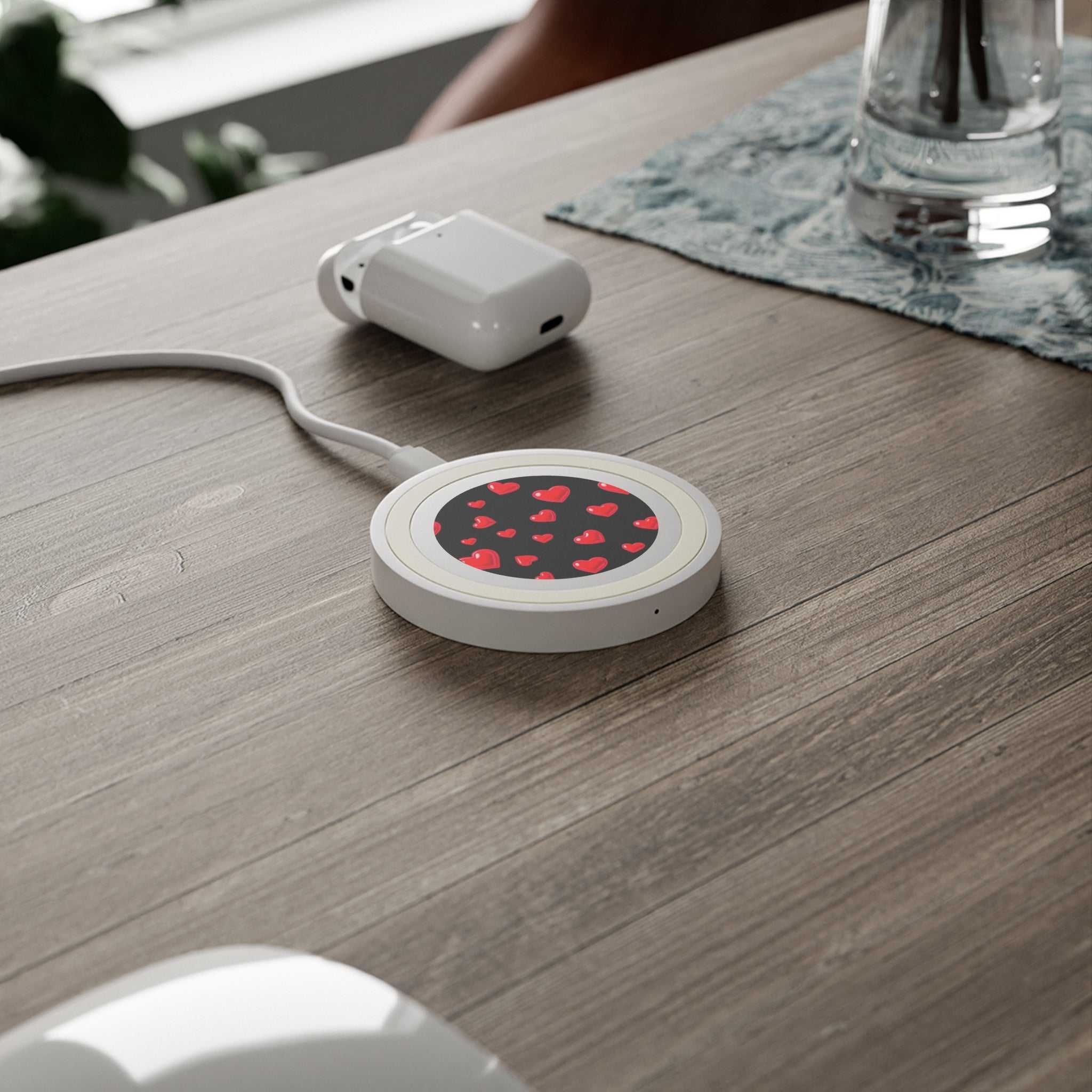 Compact black hearts design wireless charging pad with 5W power on wooden desk with charger