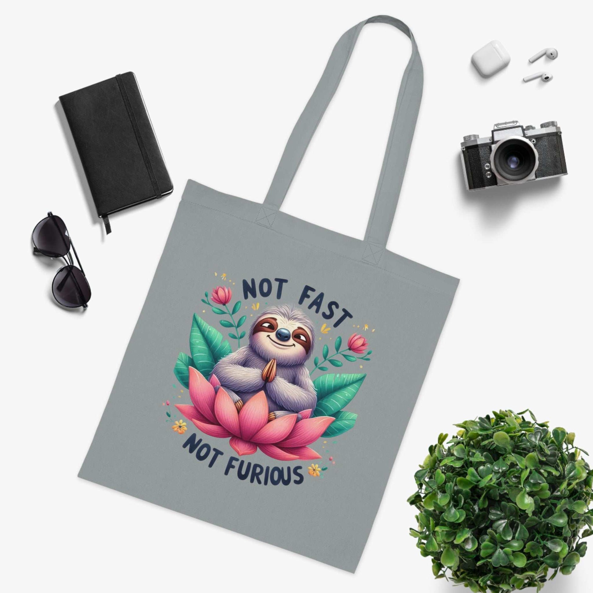 Cotton tote bag with cute sloth design, perfect for carrying essentials in style.