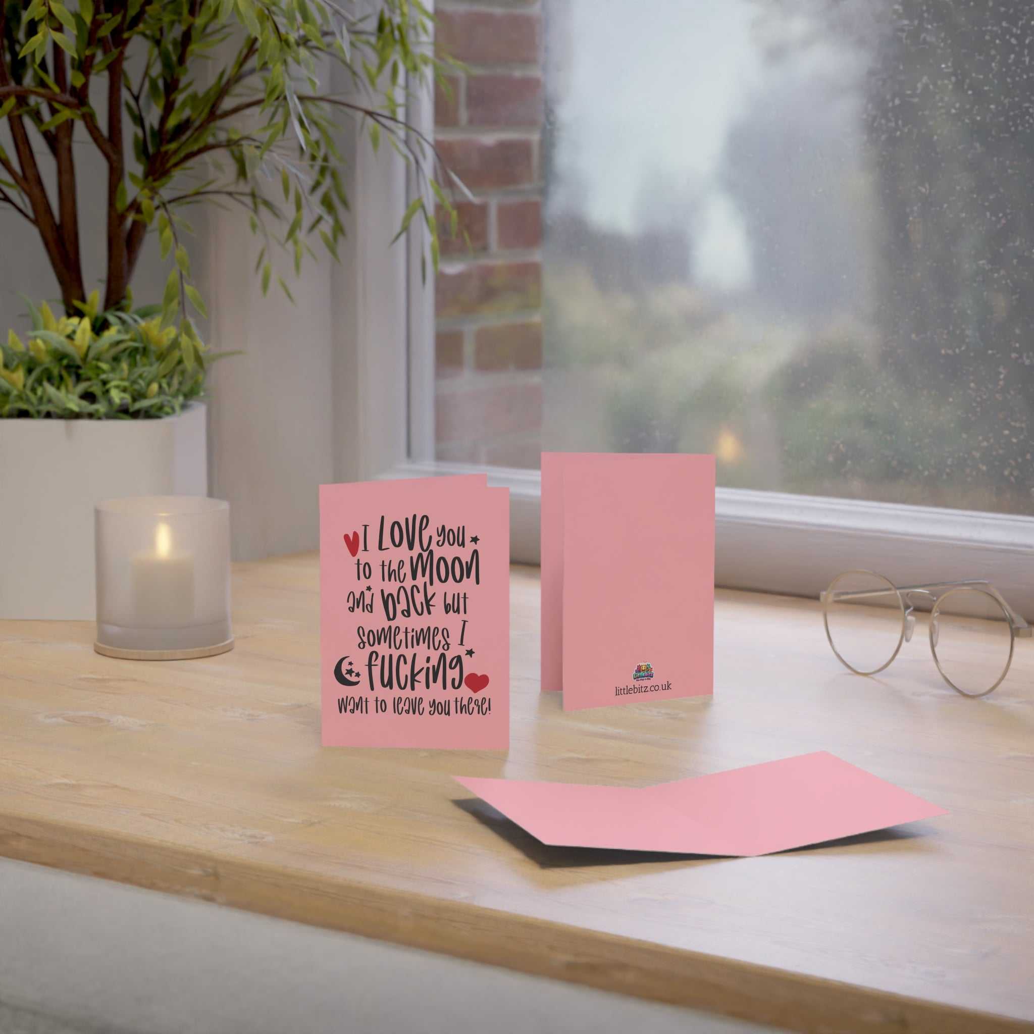 Cheeky funny greeting card on a table, A6 size, pink with envelope, humorous message, perfect for special occasions.