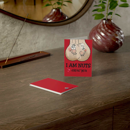 Cheeky Rude Nuts About You greeting card on a table with vase.